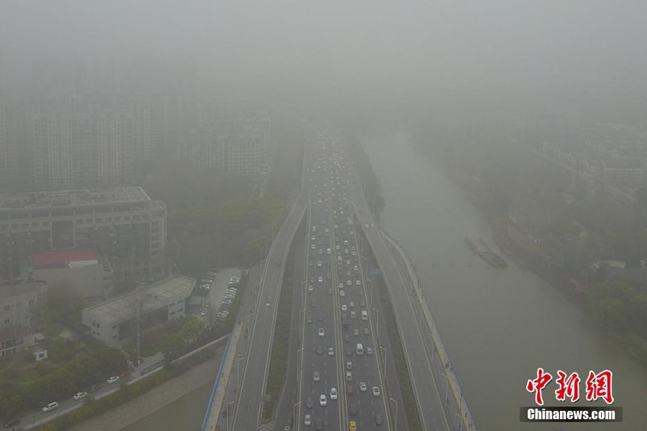 航拍南京城春雾弥漫 车辆隐约其间