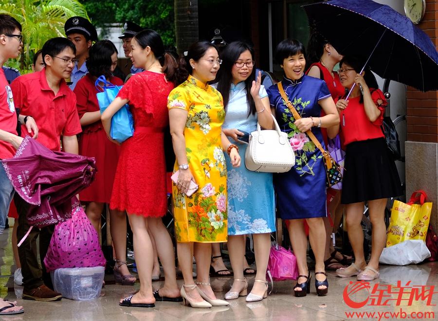 广州高考生雨中赶考家长穿红衣旗袍送考