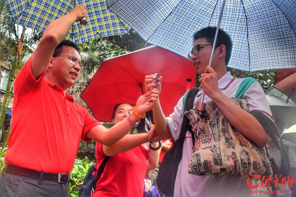 2018年6月7日，广州橙色暴雨预警下，21中考场参加高考的考生在家长、老师的祝福下从容淡定的进入考场。记者 黄巍俊 摄