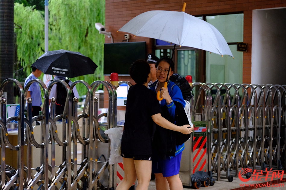 今日高考，广州大雨，在广雅中学考点，送考的家长穿起红衣、旗袍，希望考生“开门红、旗开得胜”。记者 陈秋明 摄