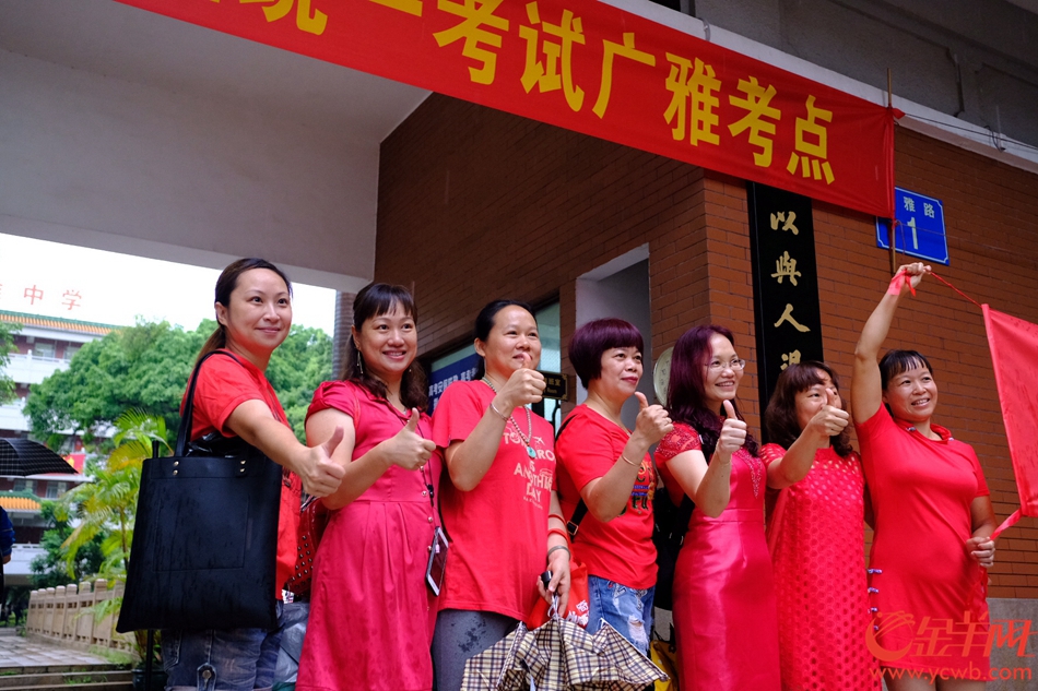 今日高考，广州大雨，在广雅中学考点，送考的家长穿起红衣、旗袍，希望考生“开门红、旗开得胜”。记者 陈秋明 摄