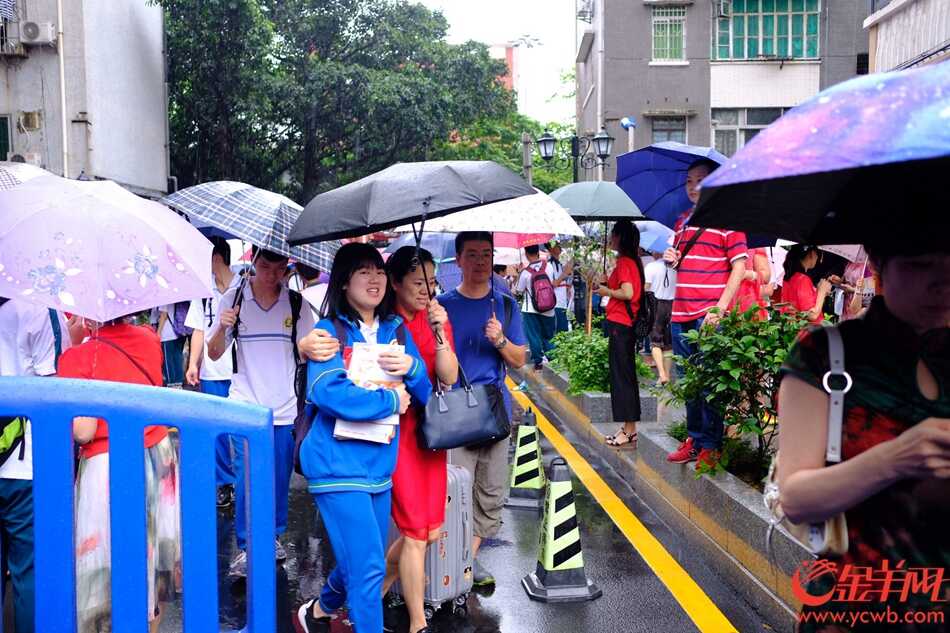 今日高考，广州大雨，在广雅中学考点，送考的家长穿起红衣、旗袍，希望考生“开门红、旗开得胜”。记者 陈秋明 摄