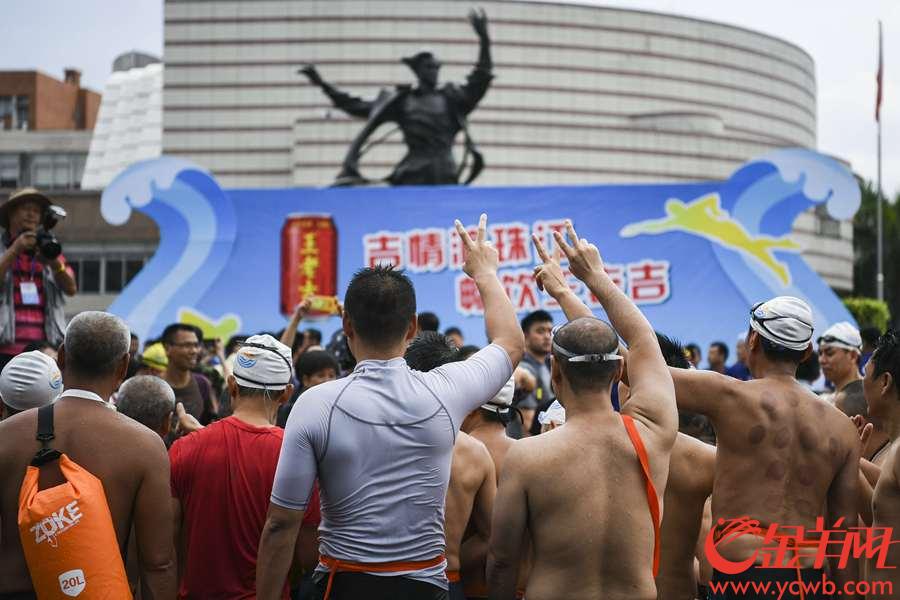 2018年7月13日，2018横渡珠江活动在中大码头至星海音乐厅之间的珠江河段举行。 图为游泳健儿们在珠江里畅游。到岸的选手们摆出各种姿势庆祝，更有球迷在身上贴满了世界杯参赛球队的国旗。 金羊网记者 周巍 摄