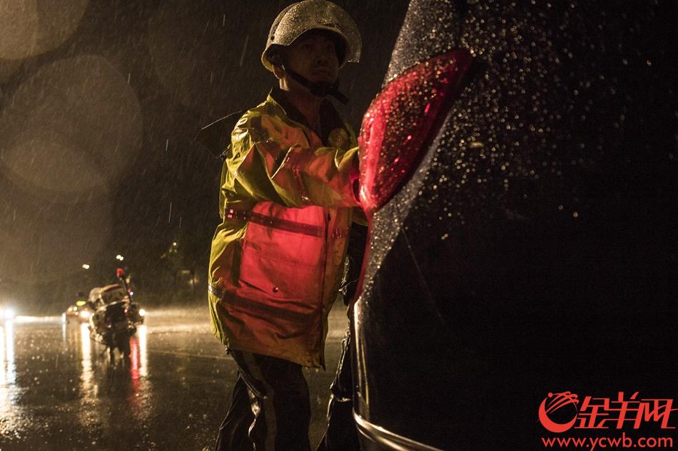 2018年9月16日晚23时许，广州交警执勤民警在广州大道中将一辆遭水浸死火的车辆推至安全区域。 记者 周巍 摄