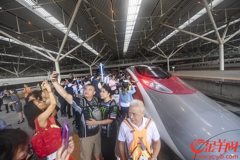 2018年9月23日7时19分，由香港西九龙站首发前往深圳北站的G5736列车准时抵达深圳北站。下车后，乘坐首班车的旅客和“动感号”列车合影留念。 记者 宋金峪 摄 