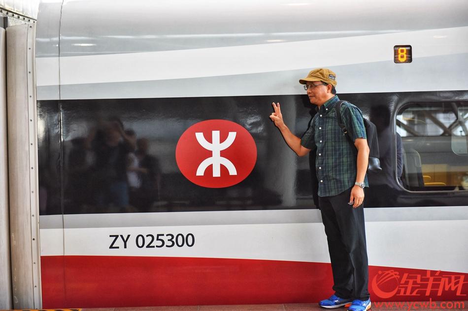 9月23日，7点19分，从香港西九龙开来深圳北站的列车进站，乘客下车后与动感列车合影。记者 王磊 摄