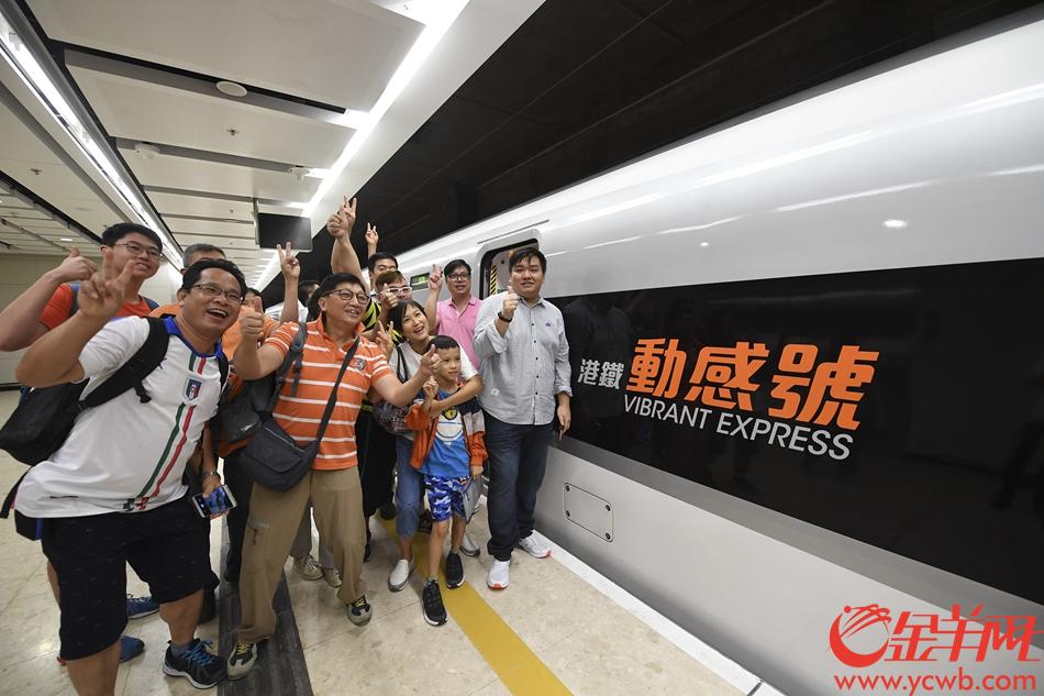 2018年9月23日，广深港高铁香港段，由香港西九龙站首发前往深圳北站的G5736列车准备开出。登车前，乘坐首班车的旅客和“动感号”列车合影留念。 记者 宋金峪 摄 