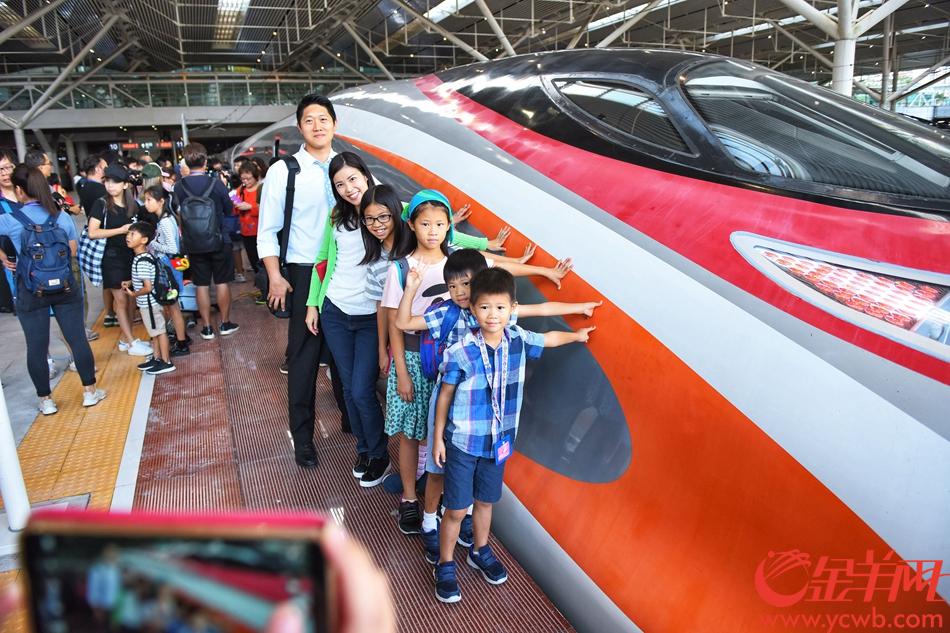 9月23日，7点19分，从香港西九龙开来深圳北站的列车进站，乘客下车后与动感列车合影。记者 王磊 摄