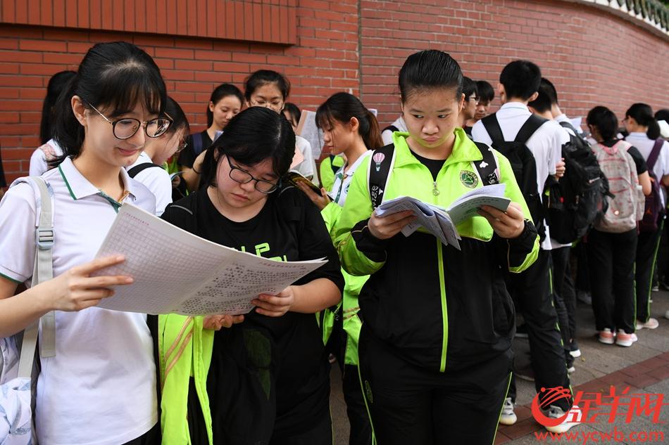 2019年6月7日，高考首日。广州市第七中学考点外，考生有序排队进场。排队之余还有考生抓紧时间多看两眼复习资料。 记者 周巍 摄