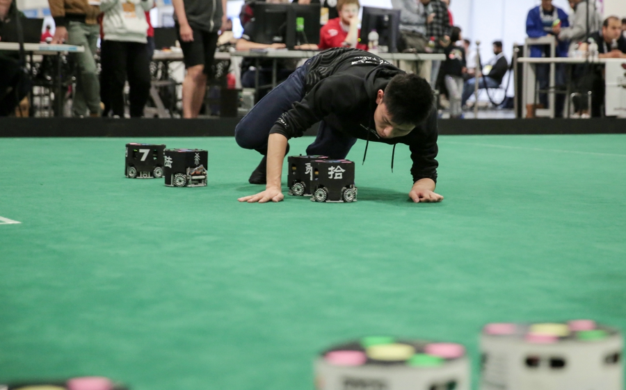7月7日，在澳大利亚悉尼，浙江大学队学生在比赛间隙调试机器人。
