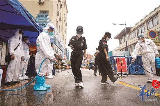 2日,在广州荔湾区中南街道海南村,工作人员为进出人员严格消毒 羊城