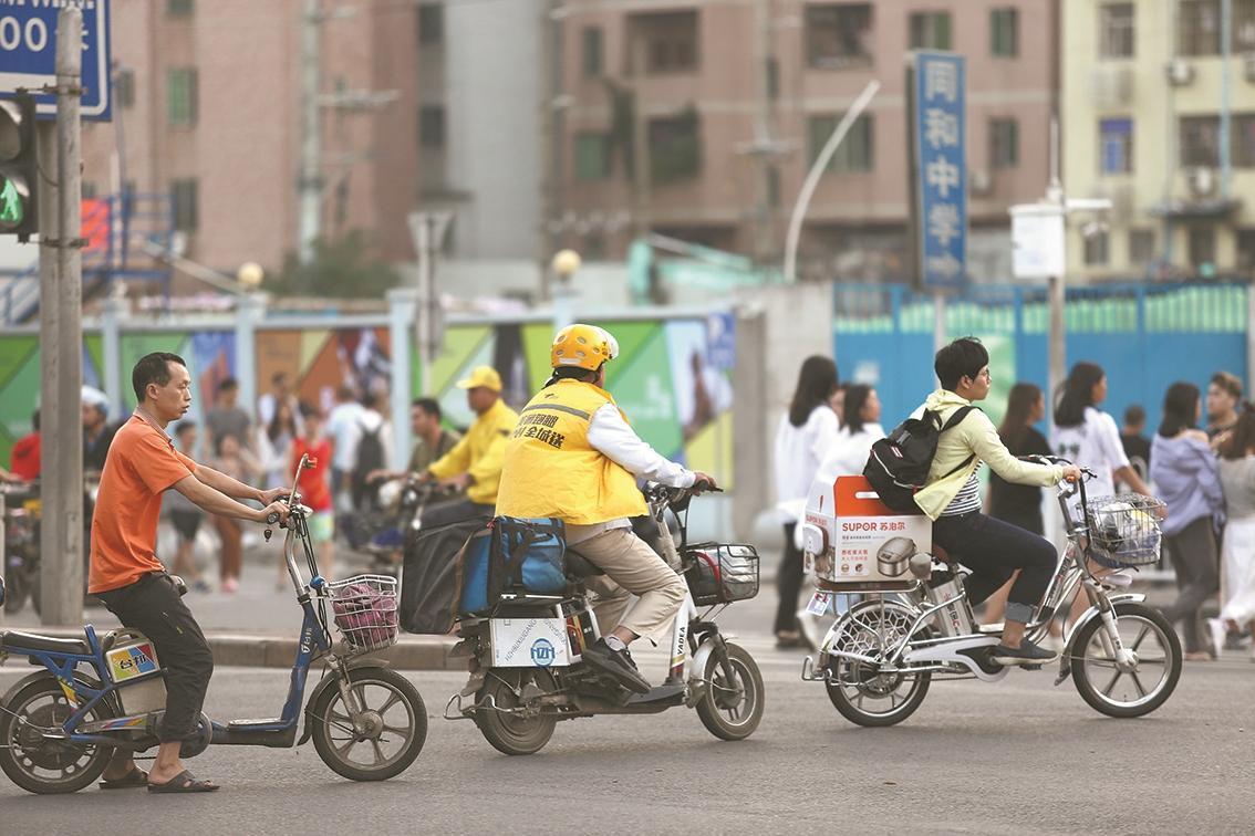 广州街上骑电动车的市民 人民视觉供图