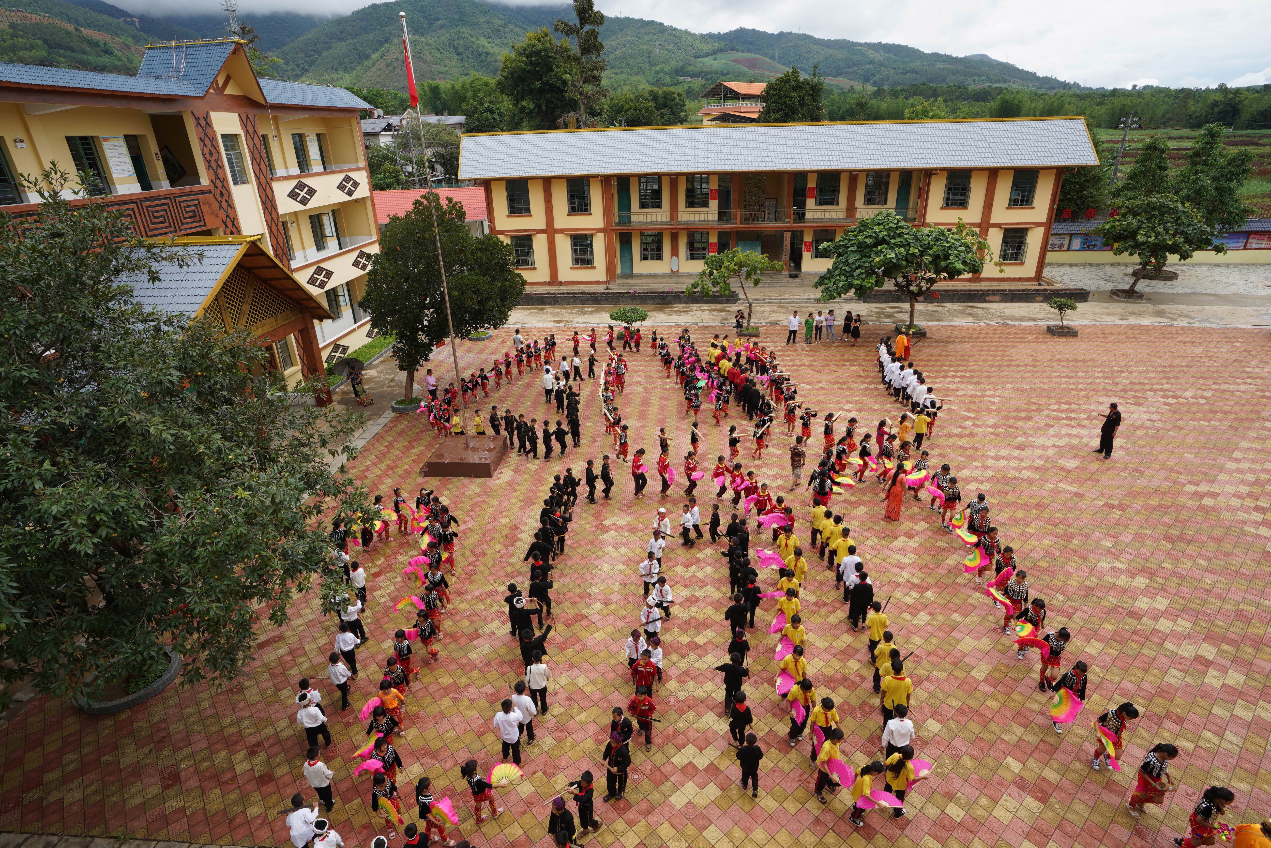 6月21日,在芒市西山乡营盘民族小学,学生们在课间操时跳民族舞.