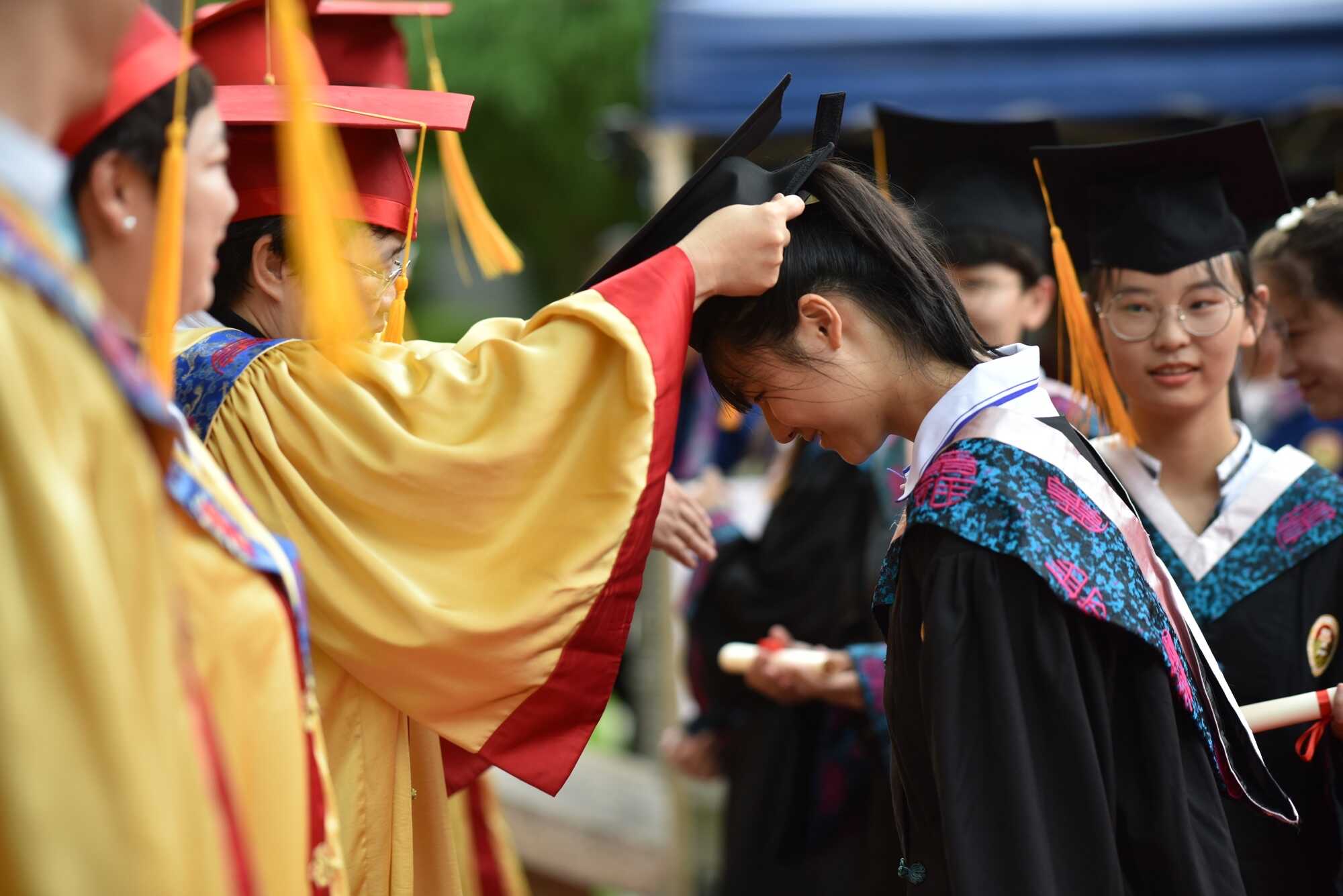 在冠冕楼前被校长逐一戴四方帽,正衣冠,握手,颁发毕业证