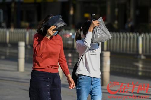 2021年2月2日，广州市区阳光普照，下午3时许，广州江南西路一带，走在路上的市民不得不伸手挡住猛烈光线的直射。羊城晚报全媒体记者 宋金峪 实习生 陈一典 摄 