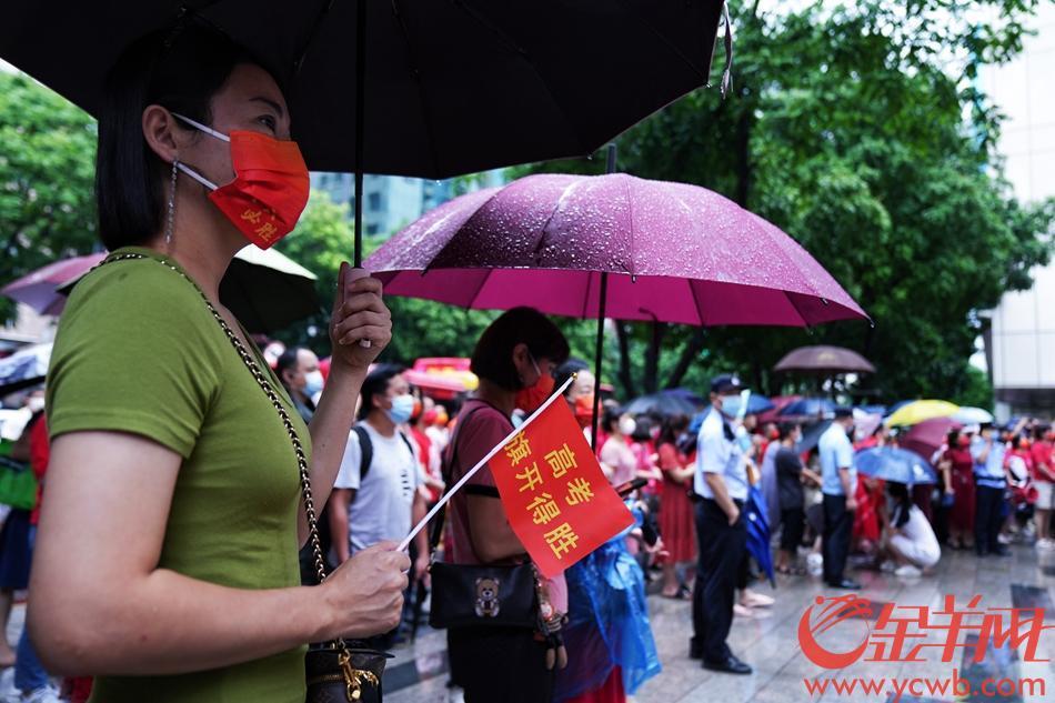 7日中午11时许，广州下起阵雨。在广州市第十六中学考场外的家长撑伞迎接考完第一场的考生。 羊城晚报全媒体记者 周巍 摄