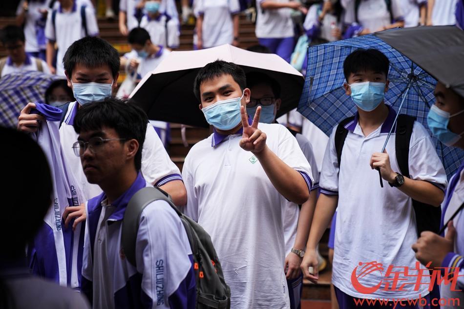 7日中午11时许，广州下起阵雨。在广州市第十六中学考场外的家长撑伞迎接考完第一场的考生。 羊城晚报全媒体记者 周巍 摄