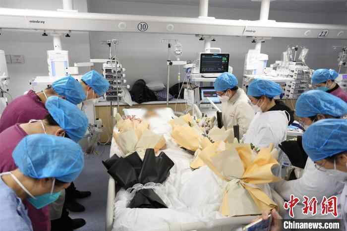 图为捐献者离开ICU病房前,科室医生及其生前同学老师向其默哀致敬。 广西医科大学第二附属医院供图