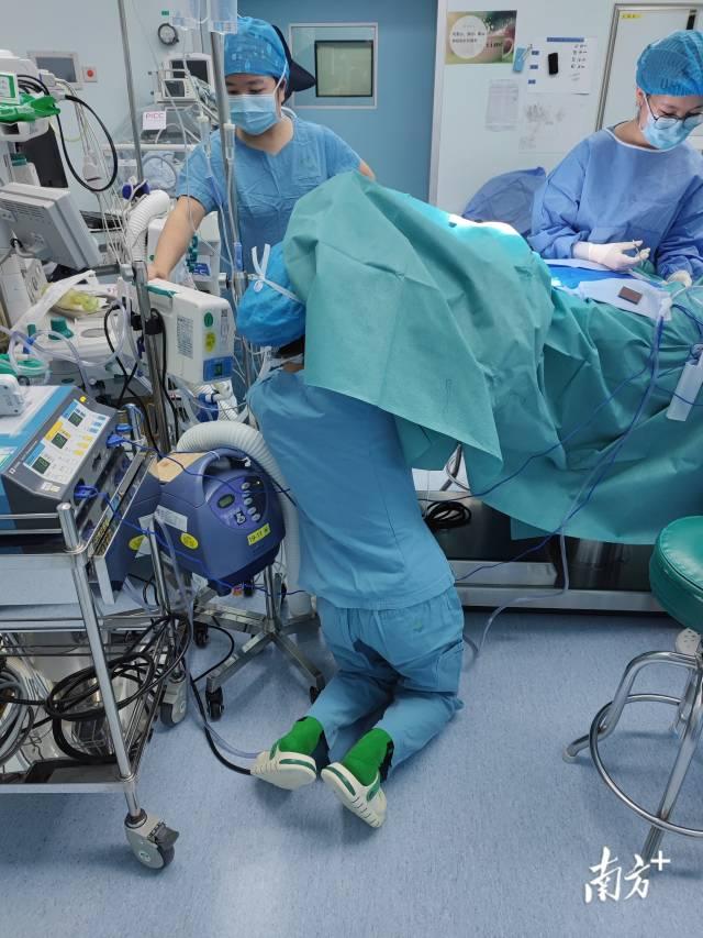 1月21日（大年三十）凌晨，深圳市儿童医院手术进行一例早产低体重儿肠梗阻手术，术中巡回护士跪在地上为患儿调整静脉通路。作者：毛建雄