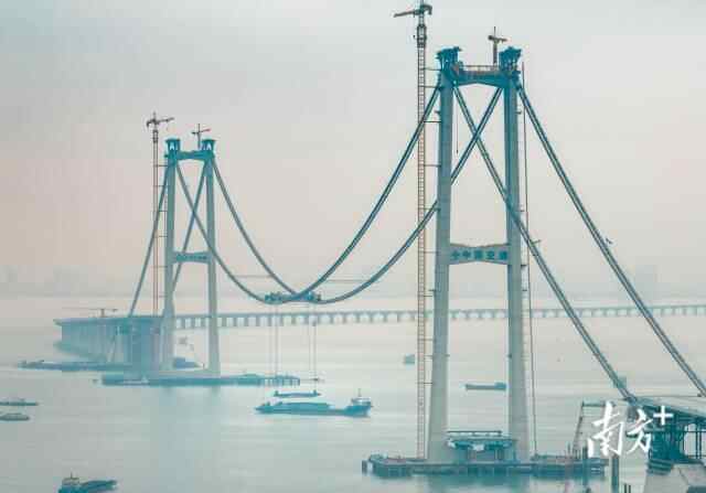 深中通道建设现场,225.8吨的钢箱梁被提升至伶仃洋大桥东、西主塔中间,由吊索稳稳固定于91米高空之上。