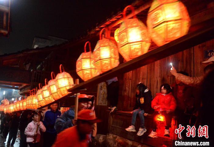 图为村民们抬着刻纸龙灯经过长汀县童坊镇彭坊古街。　张斌 摄