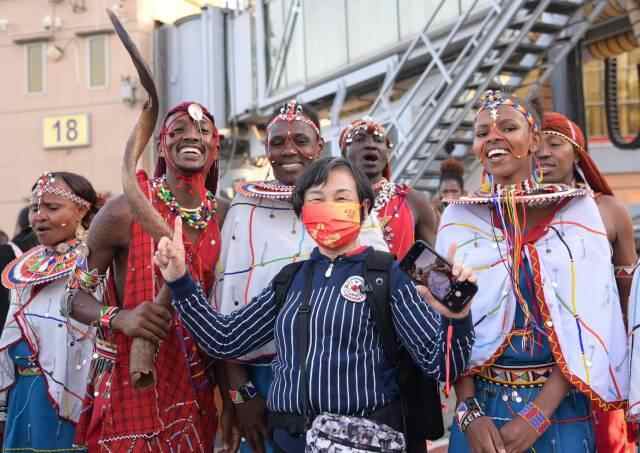  2月11日，在肯尼亚首都内罗毕乔莫·肯雅塔国际机场，中国游客和肯尼亚演员合影。图源：新华社