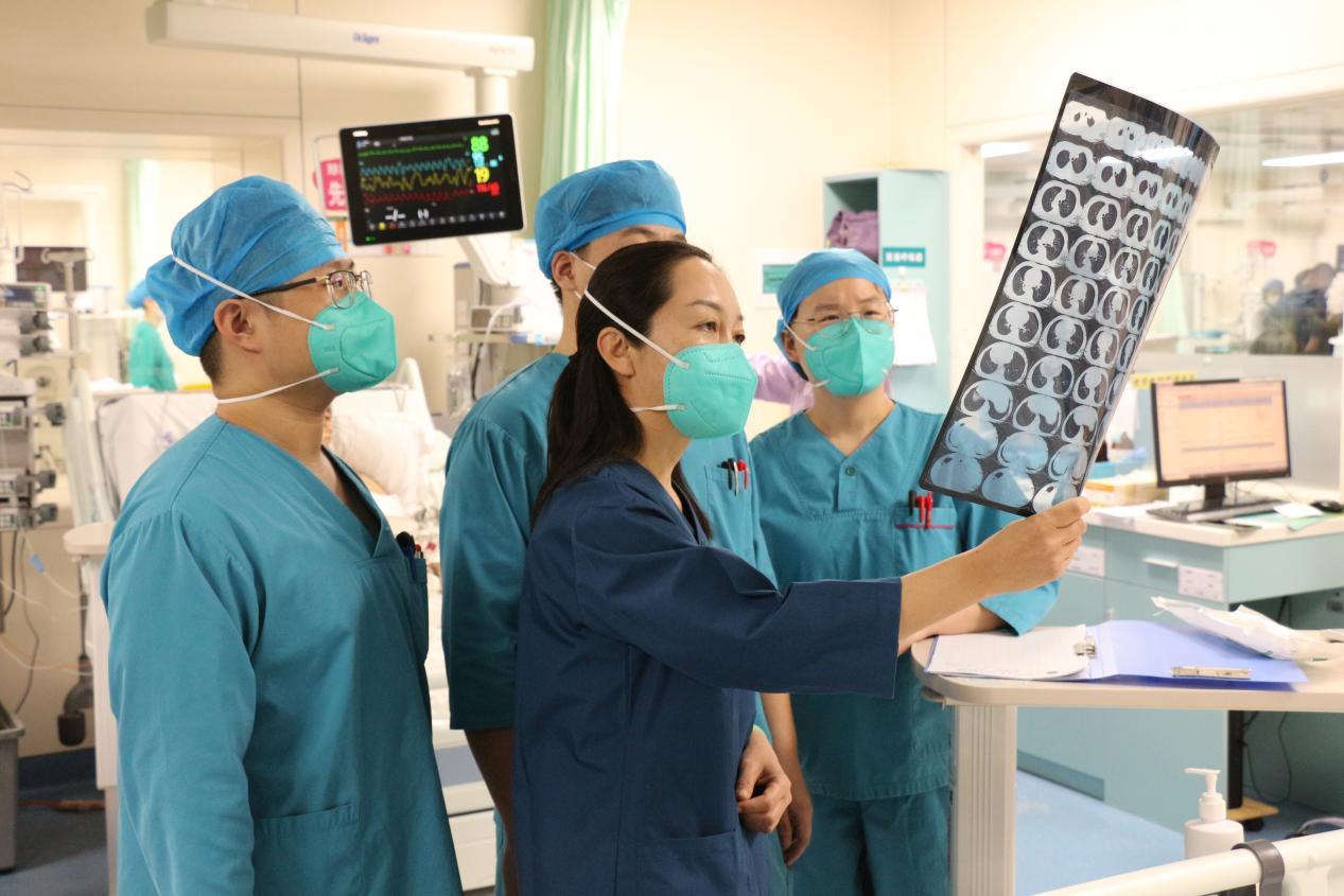 杨晓静（中）正在和团队成员一起会诊病人资料。