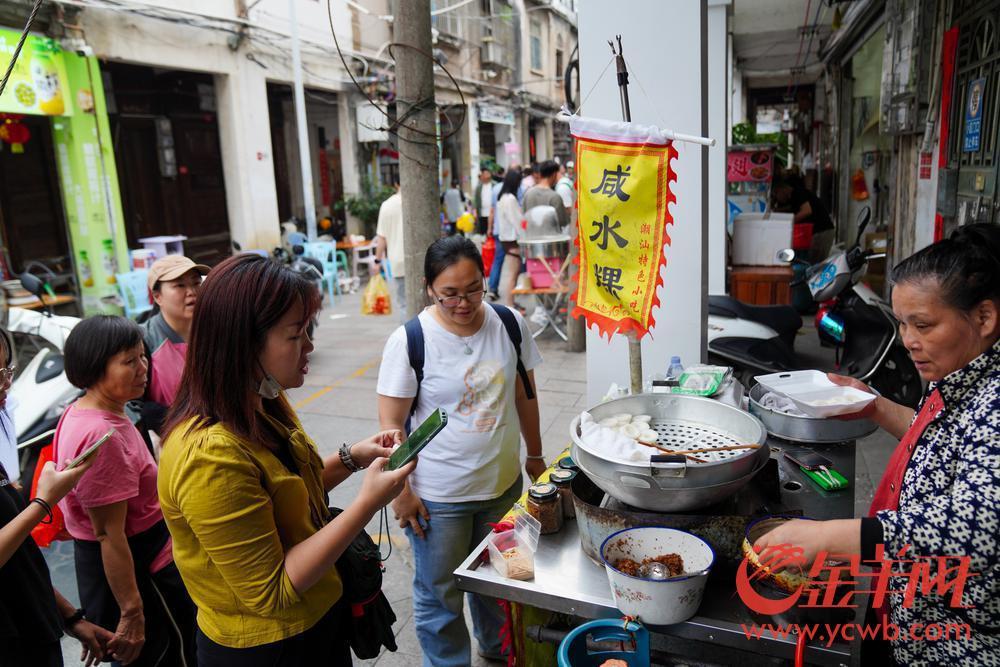2023年4月30日，潮州古城牌坊街，游客购买潮州小吃咸水粿。