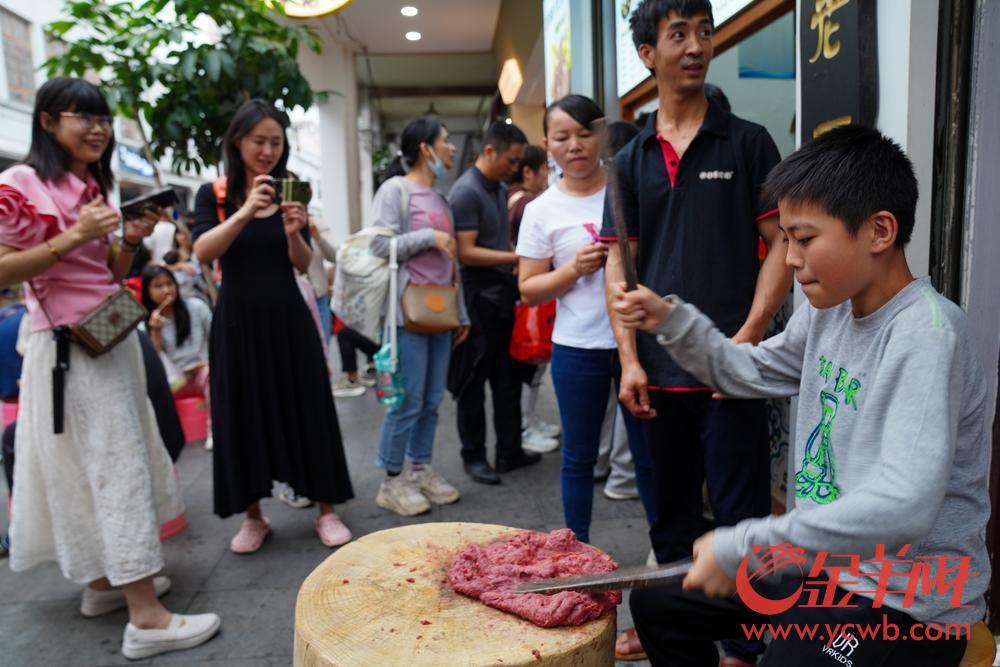 2023年4月30日，潮州古城牌坊街，游客体验手打牛肉丸制作。