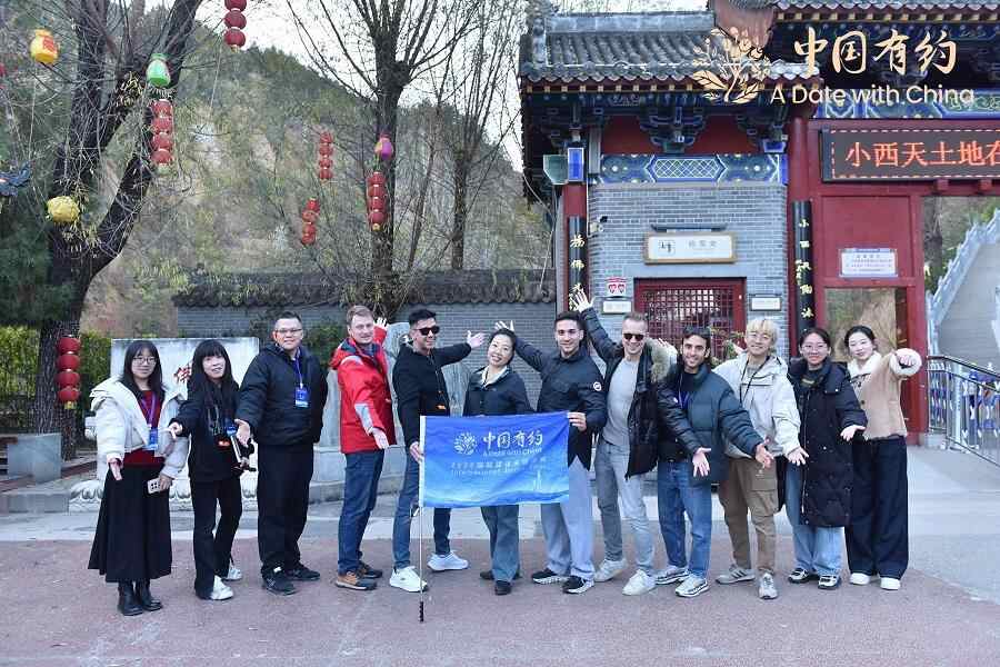 中国之约｜国际友人在临汾小西天打卡。悬浮的彩色雕塑营造出“另一个世界”